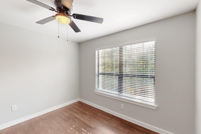 unfurnished room featuring baseboards, wood finished floors, and ceiling fan