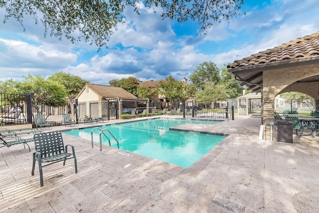 community pool featuring a patio and fence