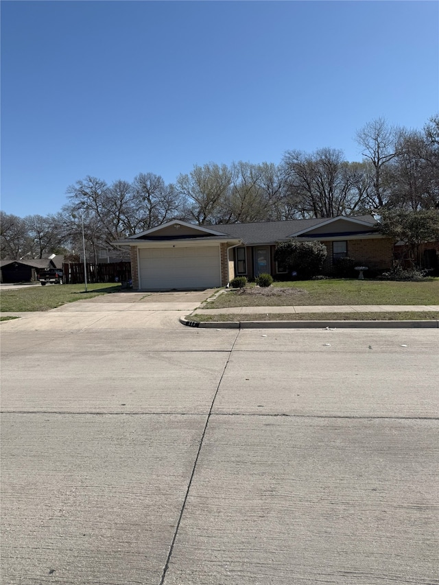 view of front of house featuring a front lawn, concrete driveway, brick siding, and a garage