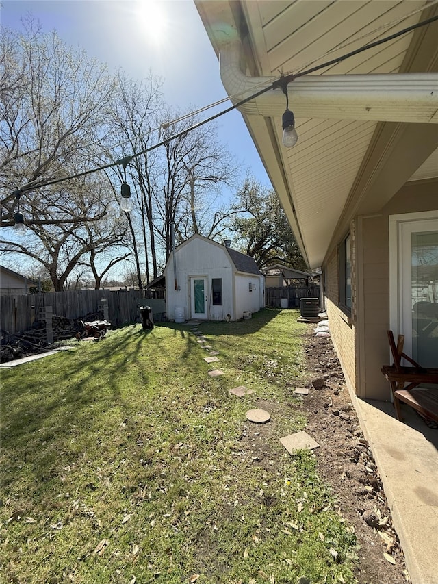view of yard featuring an outdoor structure, central AC unit, and a fenced backyard