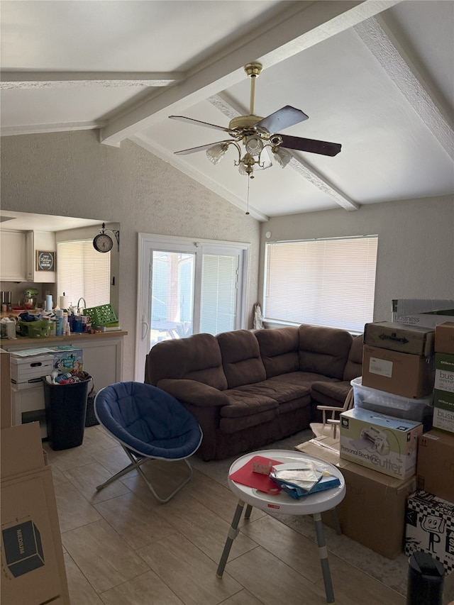 living area featuring light tile patterned floors, vaulted ceiling with beams, and a ceiling fan