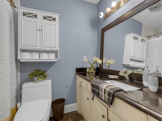 bathroom with vanity, baseboards, curtained shower, and toilet