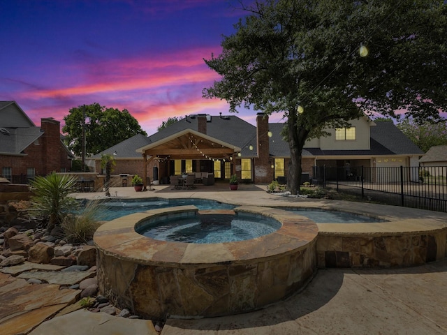 view of swimming pool with fence, a gazebo, a fenced in pool, an in ground hot tub, and a patio