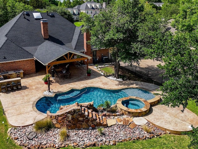 view of pool featuring a patio, a pool with connected hot tub, and fence