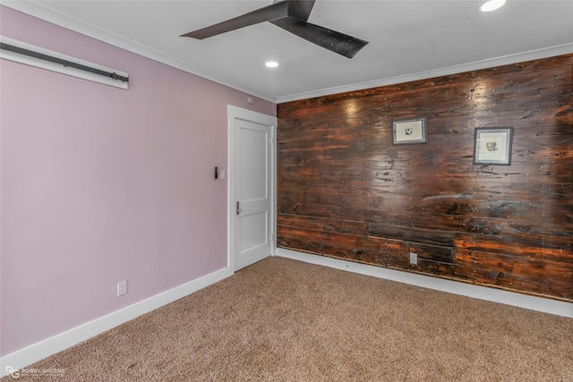 carpeted empty room featuring ornamental molding, recessed lighting, wooden walls, and baseboards