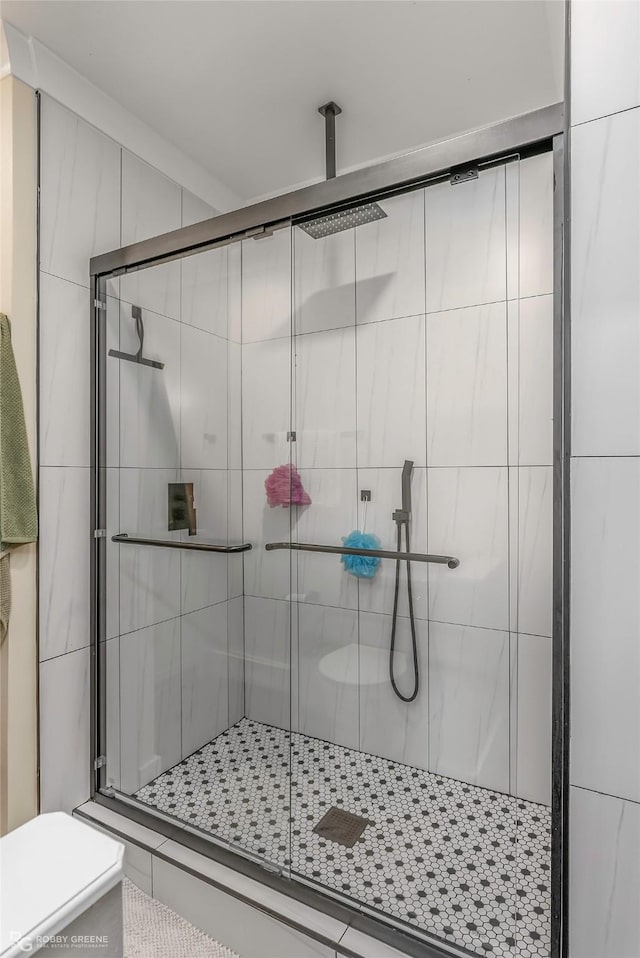 bathroom featuring toilet and a shower stall