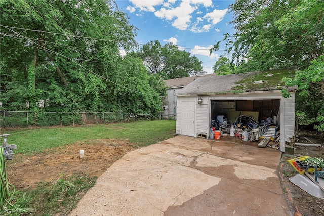 view of patio / terrace with a detached garage and an outbuilding