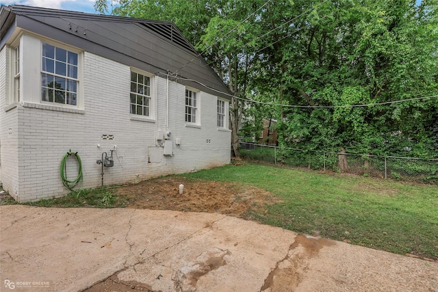 view of side of home featuring a patio area and brick siding