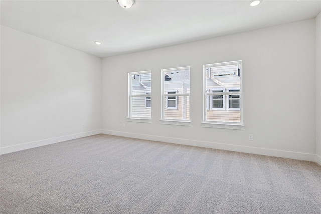 unfurnished room featuring baseboards, recessed lighting, and light carpet