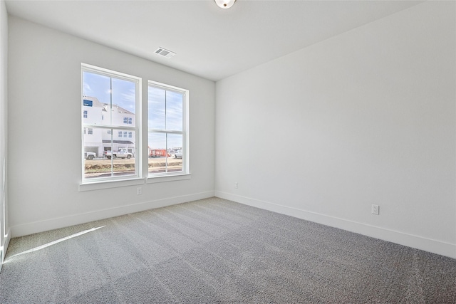 carpeted empty room featuring visible vents and baseboards