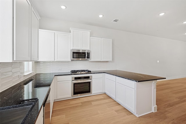 kitchen with stainless steel appliances, light wood-type flooring, visible vents, white cabinetry, and a peninsula
