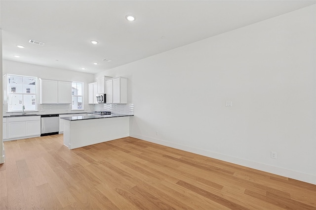 kitchen with visible vents, backsplash, appliances with stainless steel finishes, and light wood-style flooring