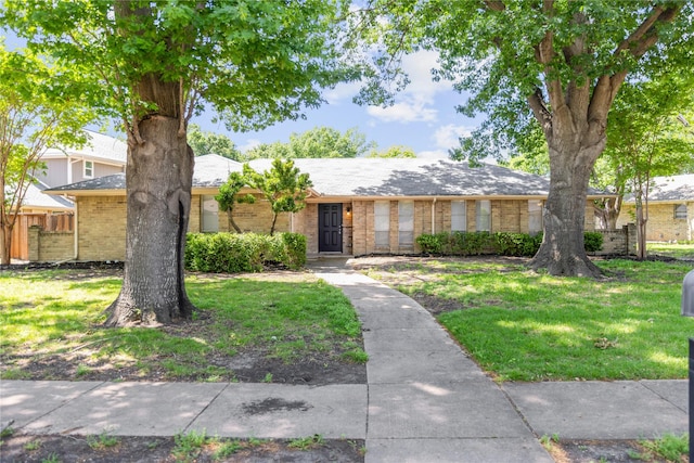 single story home featuring fence, a front yard, and brick siding