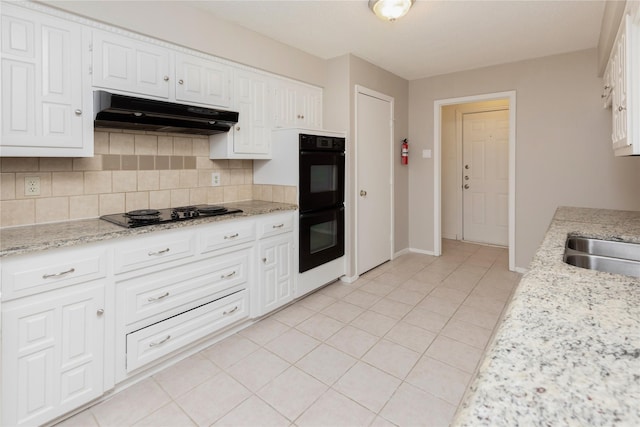 kitchen featuring black appliances, white cabinetry, decorative backsplash, and under cabinet range hood