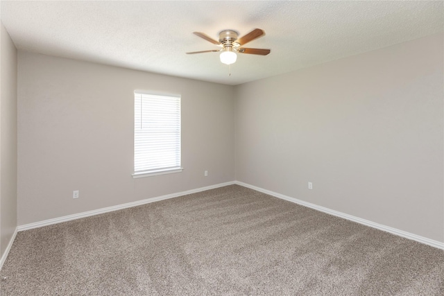 carpeted spare room featuring a textured ceiling, ceiling fan, and baseboards