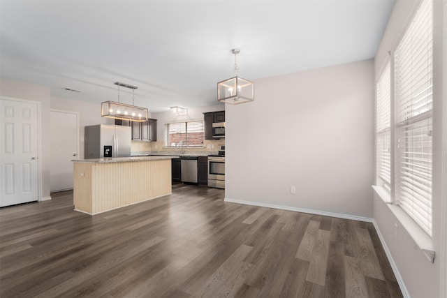 13140 Fencerow Rd, Fort Worth, TX 76244 - kitchen featuring pendant lighting, a kitchen island, dark wood finished floors, appliances with stainless steel finishes, and backsplash
