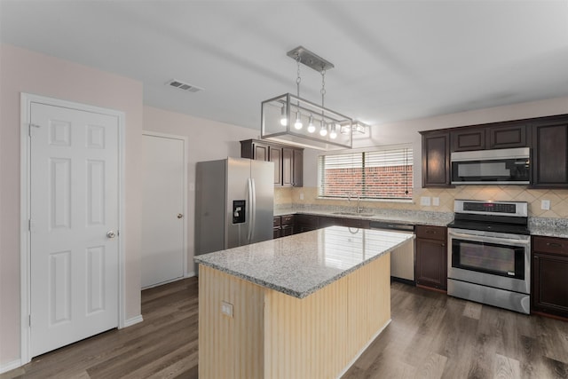 13140 Fencerow Rd, Fort Worth, TX 76244 - kitchen with visible vents, tasteful backsplash, dark wood finished floors, a sink, and stainless steel appliances