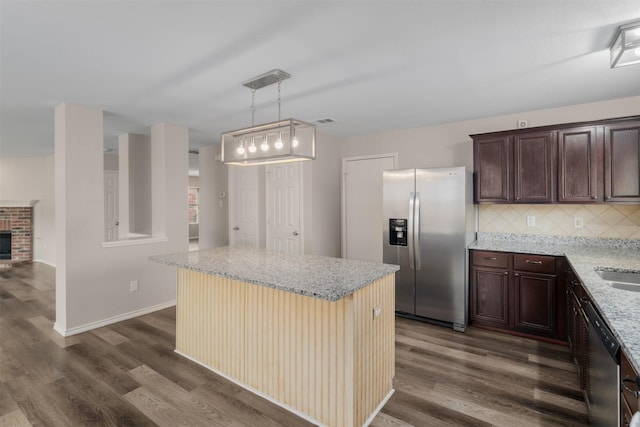 13140 Fencerow Rd, Fort Worth, TX 76244 - kitchen with dark brown cabinetry, appliances with stainless steel finishes, light stone countertops, dark wood finished floors, and tasteful backsplash