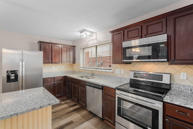13140 Fencerow Rd, Fort Worth, TX 76244 - kitchen featuring appliances with stainless steel finishes, decorative backsplash, a sink, and wood finished floors