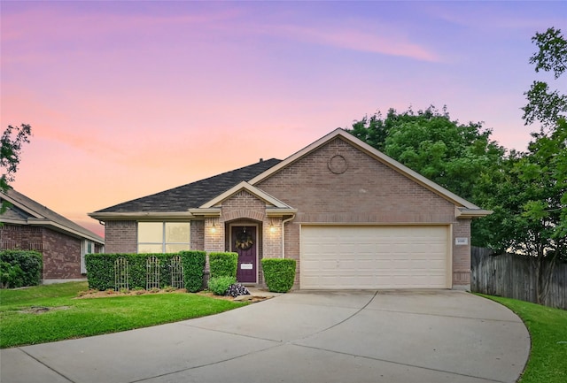 single story home with fence, an attached garage, brick siding, a yard, and driveway