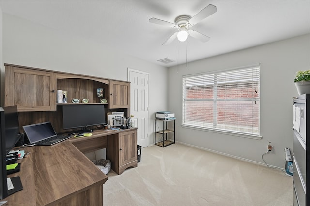 office space featuring a ceiling fan, light colored carpet, visible vents, and baseboards