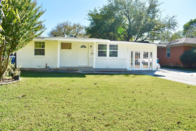 single story home featuring a front lawn, french doors, and brick siding