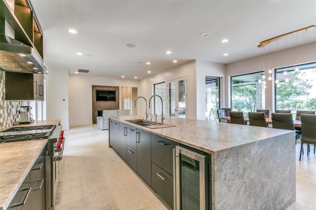 1505 Cottonwood Valley Cir N, Irving, TX 75038 - kitchen featuring beverage cooler, range with two ovens, open floor plan, modern cabinets, and wall chimney exhaust hood
