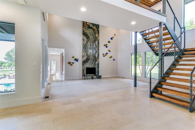 1505 Cottonwood Valley Cir N, Irving, TX 75038 - staircase featuring a high ceiling, baseboards, recessed lighting, a large fireplace, and plenty of natural light