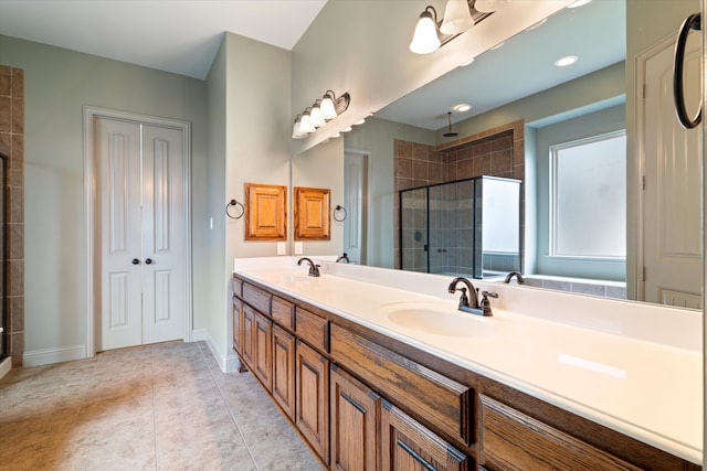 full bathroom with a sink, baseboards, a stall shower, and double vanity