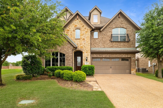 view of front of home featuring a garage, a front lawn, stone siding, central AC unit, and concrete driveway