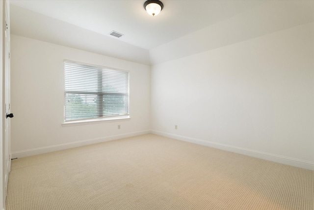 unfurnished room featuring baseboards, visible vents, and light carpet