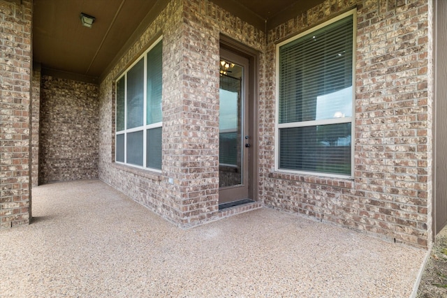 entrance to property with brick siding and covered porch