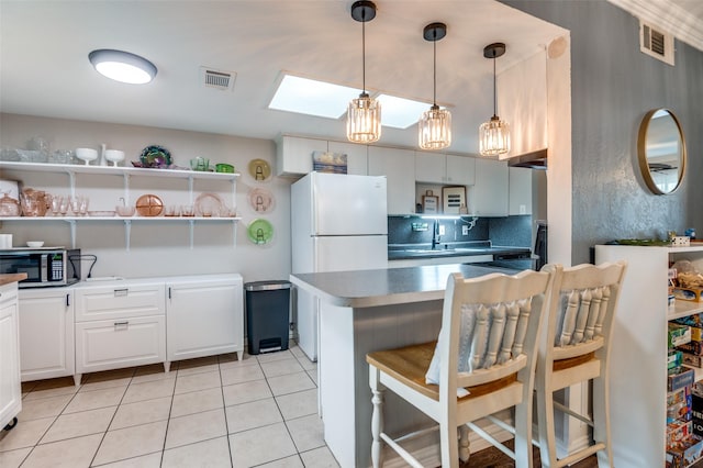 2914 Harvard St, Irving, TX 75062 - kitchen featuring visible vents, open shelves, stainless steel microwave, and a skylight