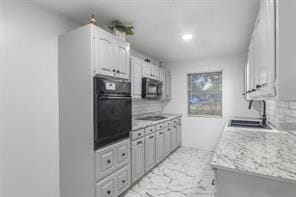 kitchen with white cabinetry, a sink, light countertops, black appliances, and marble finish floor