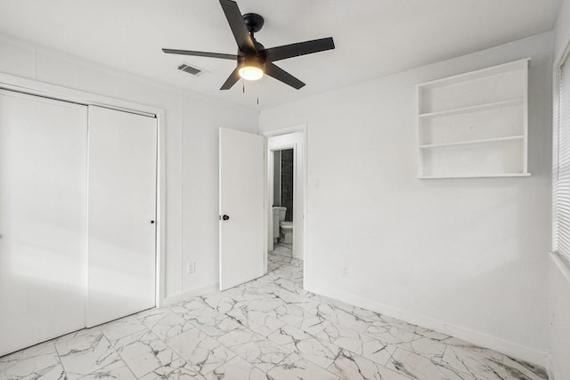 unfurnished bedroom featuring marble finish floor, visible vents, a closet, and baseboards