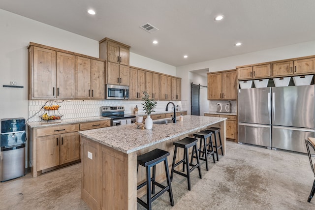 1400 Lacy Dr, Lipan, TX 76462 - kitchen with an island with sink, stainless steel appliances, a kitchen bar, a sink, and concrete flooring