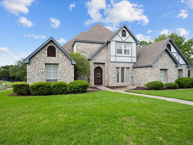 8313 Jonquil Dr, Waco, TX 76708 - tudor-style house with a front lawn, roof with shingles, and stone siding