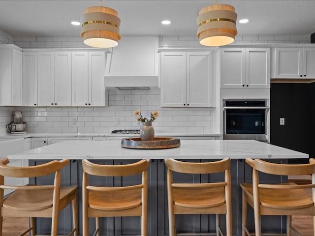 8313 Jonquil Dr, Waco, TX 76708 - kitchen featuring white cabinets, stainless steel appliances, decorative backsplash, and a kitchen island