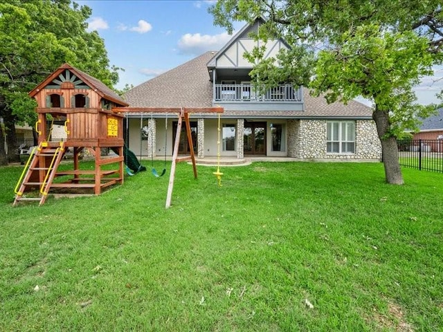 8313 Jonquil Dr, Waco, TX 76708 - rear view of property with fence, a balcony, a shingled roof, a playground, and a yard