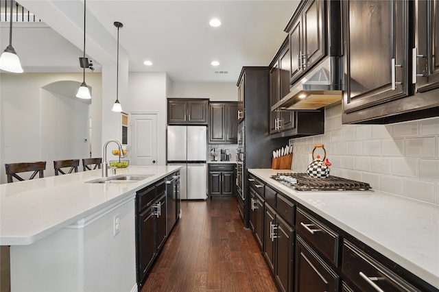 641 Mangrove Trl, Saginaw, TX 76131 - kitchen featuring hanging light fixtures, appliances with stainless steel finishes, a sink, dark wood finished floors, and under cabinet range hood