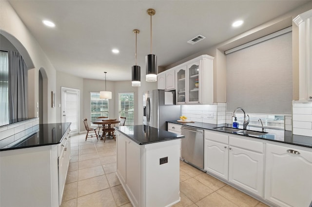 kitchen featuring a kitchen island, dark countertops, recessed lighting, a sink, and appliances with stainless steel finishes
