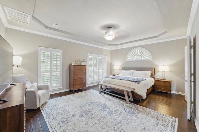 bedroom featuring a raised ceiling, dark wood-type flooring, and visible vents