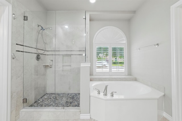bathroom featuring a bath and a shower stall