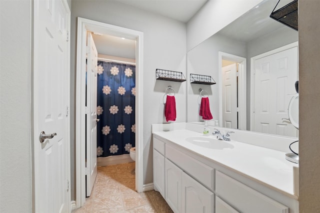 bathroom with a shower with curtain, tile patterned floors, baseboards, vanity, and toilet