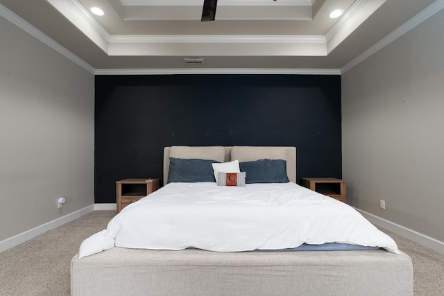 bedroom featuring ornamental molding, a tray ceiling, carpet flooring, and baseboards