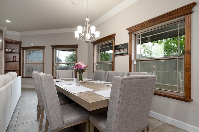 dining area featuring baseboards, ornamental molding, an inviting chandelier, and light tile patterned flooring