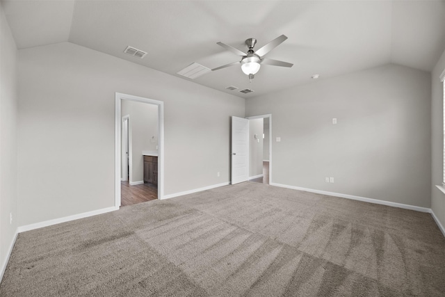 unfurnished bedroom featuring visible vents, ensuite bathroom, baseboards, carpet floors, and vaulted ceiling