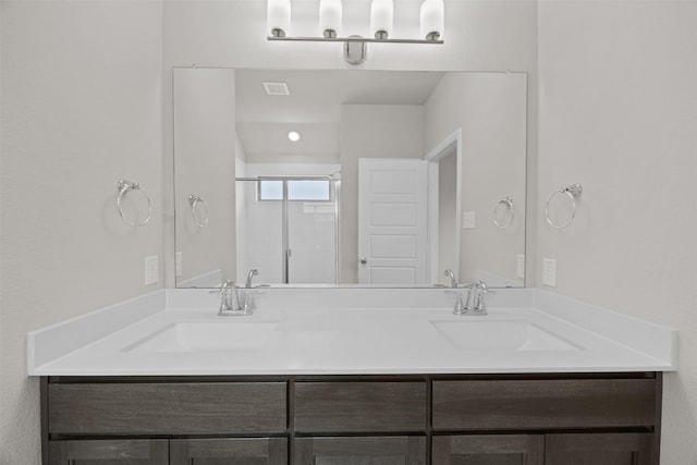 full bath featuring a stall shower, double vanity, a sink, and visible vents