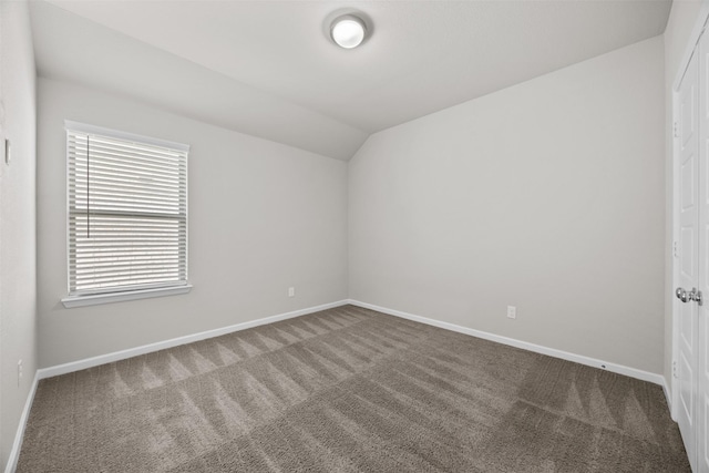 unfurnished room with baseboards, lofted ceiling, and carpet flooring