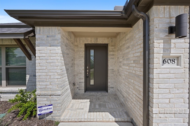 entrance to property featuring brick siding